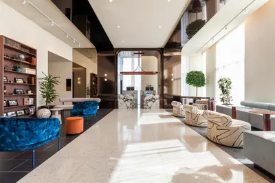 a lobby of a building with blue chairs and tables at Hyatt Centric Montreal in Montréal