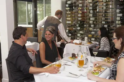 a group of people sitting at a table in a restaurant at L'Auberge Du Lac St-Pierre in Trois-Rivières