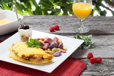 a plate of breakfast food and a glass of orange juice at L'Auberge Du Lac St-Pierre in Trois-Rivières