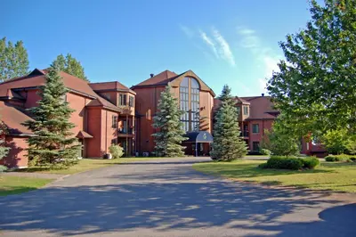 a road in front of a large building at L'Auberge Du Lac St-Pierre in Trois-Rivières