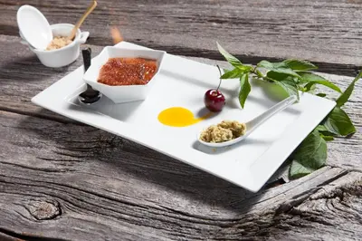 a white plate with food on a wooden table at L'Auberge Du Lac St-Pierre in Trois-Rivières