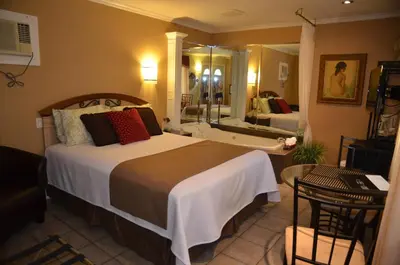a bedroom with a large bed and a bathroom at Motel Derfal in Repentigny