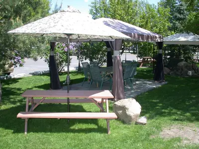 a picnic table and an umbrella in the grass at Motel Derfal in Repentigny