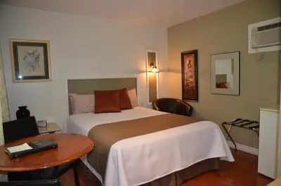 a hotel room with a bed and a table at Motel Derfal in Repentigny