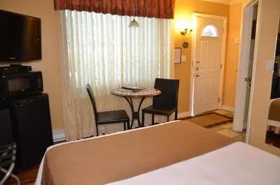 a hotel room with a bed and a table and chairs at Motel Derfal in Repentigny