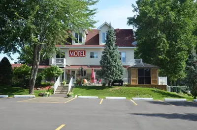 a hotel with a parking lot in front of it at Motel Derfal in Repentigny