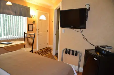 a bedroom with a bed and a flat screen tv on the wall at Motel Derfal in Repentigny