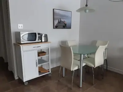 a kitchen with a table with a microwave and chairs at Magog Waterfront Condo in Magog-Orford
