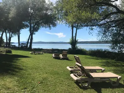 a group of lawn chairs sitting in the grass near a lake at Magog Waterfront Condo in Magog-Orford