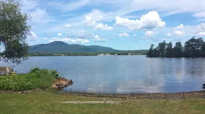 a view of a large lake with mountains in the background at Magog Waterfront Condo in Magog-Orford
