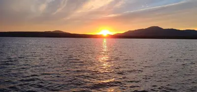 a sunset over a large body of water at Magog Waterfront Condo in Magog-Orford