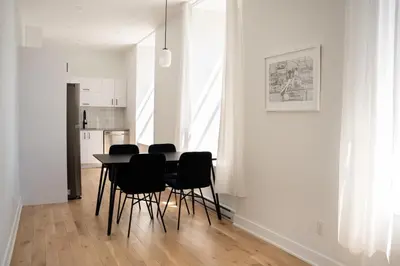 a dining room with a black table and black chairs at Maison Rasco by Luxury In Transit in Montréal