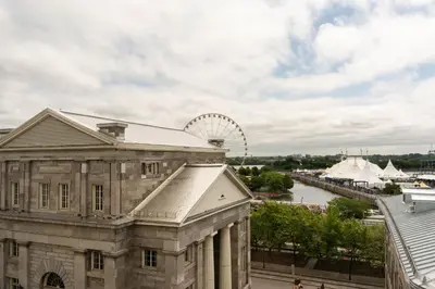 an old building with a ferris wheel in the background at Maison Rasco by Luxury In Transit in Montréal