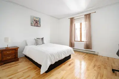 a white bedroom with a bed and a window at Centennial 6-Bedroom Waterfront Palace Sleeps 14 in Montréal