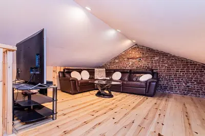 a living room with leather couches and a brick wall at Centennial 6-Bedroom Waterfront Palace Sleeps 14 in Montréal