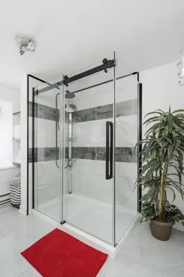 a glass shower in a room with a red rug at Centennial 6-Bedroom Waterfront Palace Sleeps 14 in Montréal