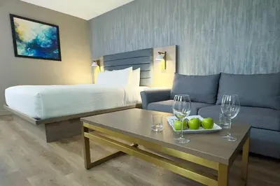 a hotel room with a bed and a table with wine glasses at Radisson Hotel Montreal Airport in Saint-Laurent