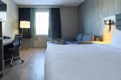 a hotel room with a bed and a desk at Radisson Hotel Montreal Airport in Saint-Laurent