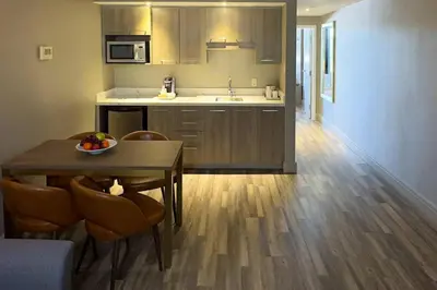 a kitchen with a table and chairs and a kitchen with a sink at Radisson Hotel Montreal Airport in Saint-Laurent