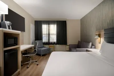 a hotel room with a bed and a desk at Radisson Hotel Montreal Airport in Saint-Laurent