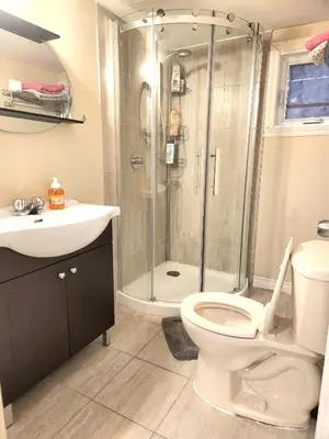 a bathroom with a shower and a toilet and a sink at Cozy spacious Apt In Laval, Greater Montreal in Laval