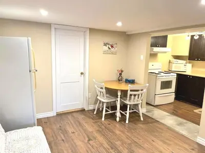 a kitchen with a table and chairs in a room at Cozy spacious Apt In Laval, Greater Montreal in Laval