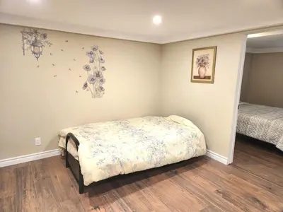 a bedroom with a bed in the corner of the room at Cozy spacious Apt In Laval, Greater Montreal in Laval