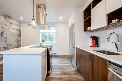 a kitchen with white countertops and wooden cabinets at Nice River & Mountain View+4 Beds+Free parking in McMasterville