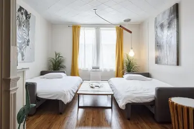 a room with two beds and a table in it at MtlVacationRentals - MTL ZOO in Montréal