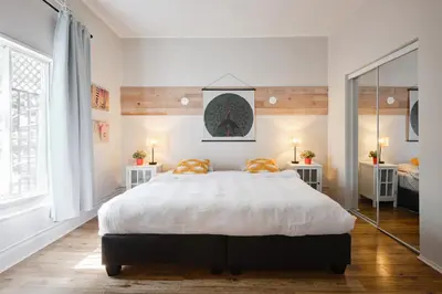 a bedroom with a large bed with two orange pillows at MtlVacationRentals - MTL ZOO in Montréal