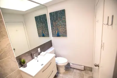 a bathroom with a sink and a toilet and a mirror at MtlVacationRentals - MTL ZOO in Montréal