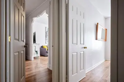 an open hallway with white walls and wooden floors at MtlVacationRentals - MTL ZOO in Montréal