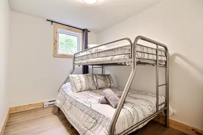 a bedroom with two bunk beds in a room at Sutton Wellness cabin #267 Rez-de-chaussée in Sutton