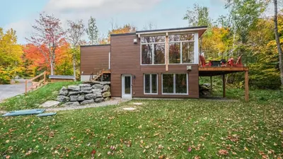 a small house with a deck on top of a yard at Sutton Wellness cabin #267 Rez-de-chaussée in Sutton
