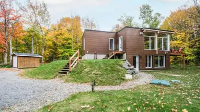 a house in the woods with a driveway at Sutton Wellness cabin #267 Rez-de-chaussée in Sutton