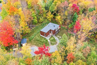 an aerial view of a house in the middle of a forest at Sutton Wellness cabin #267 Rez-de-chaussée in Sutton