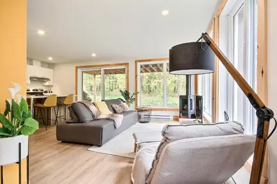 a living room with two couches and a table at Sutton Wellness cabin #267 Rez-de-chaussée in Sutton