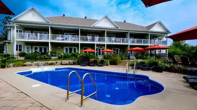 a resort with a swimming pool in front of a building at Superbe condo - Navette de Ski Gratuite #202 in Bromont