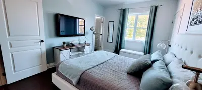 a bedroom with a bed and a flat screen tv at Superbe condo - Navette de Ski Gratuite #202 in Bromont
