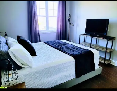 a bedroom with a bed with a television and a window at Superbe condo - Navette de Ski Gratuite #202 in Bromont