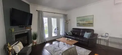 a living room with a leather couch and a fireplace at Superbe condo - Navette de Ski Gratuite #202 in Bromont