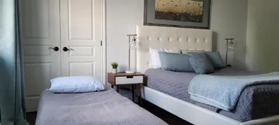a bedroom with two beds next to a door at Superbe condo - Navette de Ski Gratuite #202 in Bromont