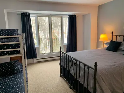 a bedroom with a bed and a large window at Condo Club Azur Plage Memphremagog in Magog-Orford