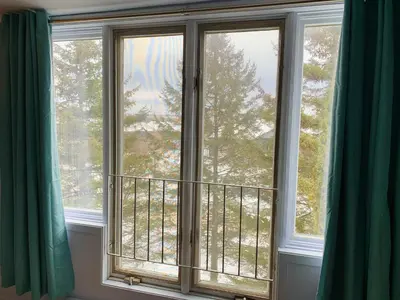 two windows in a room with green curtains at Condo Club Azur Plage Memphremagog in Magog-Orford