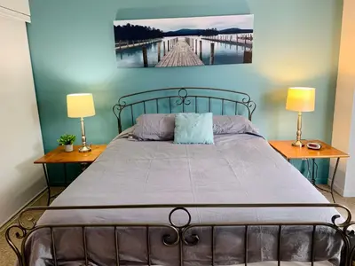 a bedroom with a bed with two lamps and a painting on the wall at Condo Club Azur Plage Memphremagog in Magog-Orford
