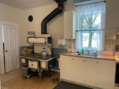 a kitchen with a stove and a sink in it at La Maison des Leclerc in Trois-Rivières