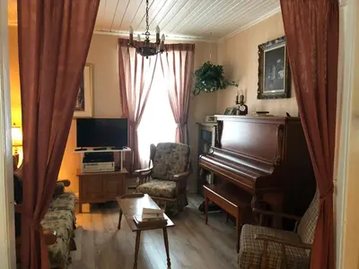 a living room with a piano and a chair at La Maison des Leclerc in Trois-Rivières