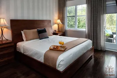 a bedroom with a large bed with a tray with drinks on it at Le Champlain 101- Condo avec Piscine in Bromont