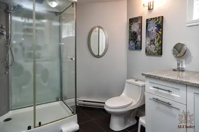 a bathroom with a toilet and a glass shower at Le Champlain 101- Condo avec Piscine in Bromont