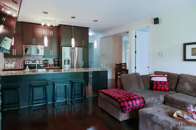 a living room with a couch and a kitchen at Le Champlain 101- Condo avec Piscine in Bromont